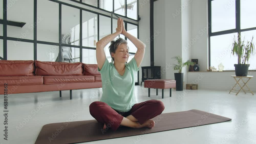 Old woman make yoga exercise at home. Mature woman have meditation in studio. Relax her body and mind to release all bad things in her life Old woman make yoga exercise at home. Mature woman have meditation in studio. Relax her body and mind to release all bad things in her life