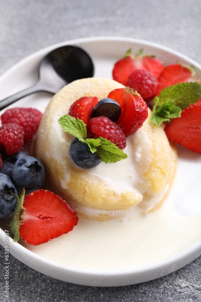 Delicious vanilla fondant served with fresh berries on grey textured table, closeup Delicious vanilla fondant served with fresh berries on grey textured table, closeup