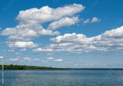 Blue sky and white clouds over a peaceful lake in Canada