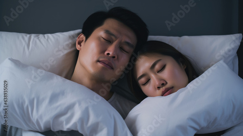 Snoring man. Couple in bed, men snoring and women can not sleep, covering ears with pillow for snore noise. Young interracial couple, Asian woman, Caucasian men sleeping in bed at home.