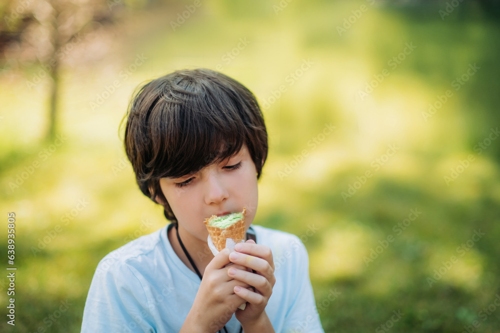 Outdoor portrait of young boy eating ice cream in crispy cone. Outdoor portrait of young boy eating ice cream in crispy cone.