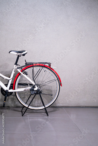 Retro old becycle with red and white color front concrete wall background. Vintage old style filtered photo photo