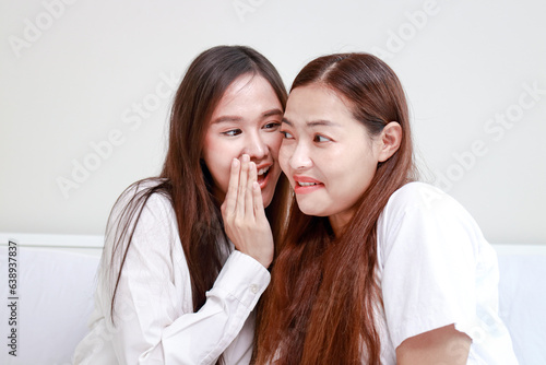 Two Asian women living together at home, both smiling happily. Lesbian couple. gossip woman