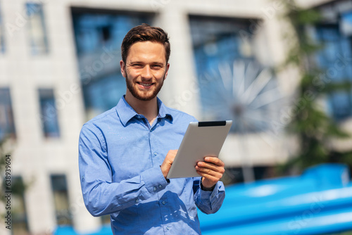 Ginger businessman working outdoors on his tablet