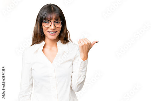 Young caucasian woman over isolated chroma key background pointing to the side to present a product