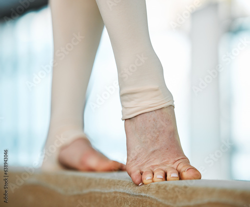 Feet, beam and balance, gymnastics and fitness with person in gym, training for performance or competition. Closeup, challenge and strong, workout and gymnast exercise, active and talent with art © Mumtaaz D/peopleimages.com