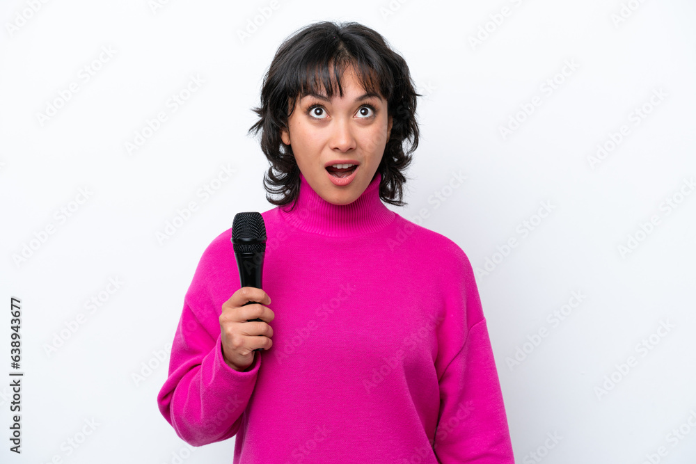 Young Argentinian singer woman isolated on white background looking up and with surprised expression Young Argentinian singer woman isolated on white background looking up and with surprised expression