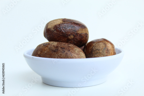 Dried nutmeg or seed of Myristica fragrans, or biji pala. Isolated on white background