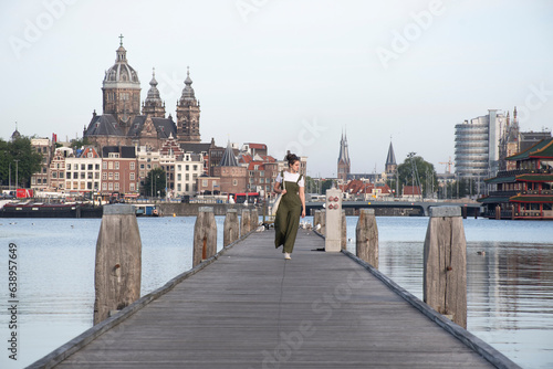 Chica caminando por el muelle en Amsterdam