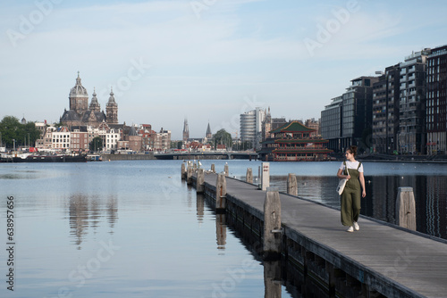 Chica caminando por el muelle en Amsterdam