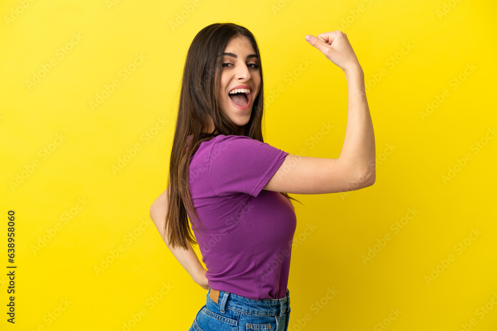 Young caucasian woman isolated on yellow background doing strong gesture Young caucasian woman isolated on yellow background doing strong gesture