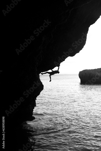 silueta de chico escalando en la costa