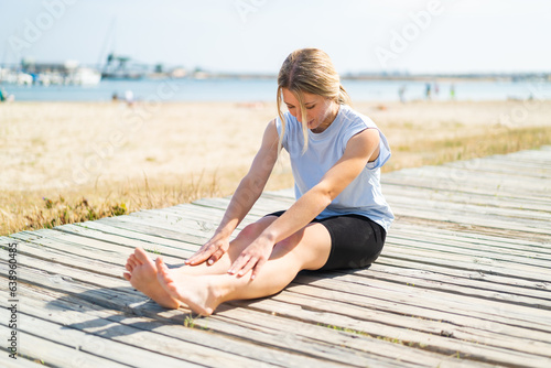 Young blonde woman at outdoors doing yoga
