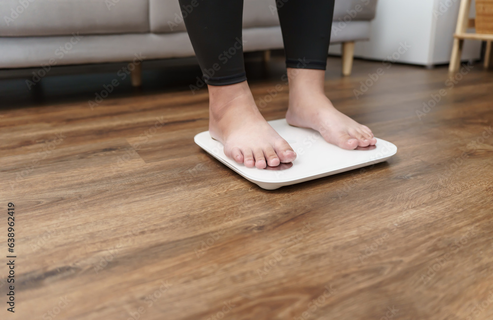 Fat diet and scale feet standing on electronic scales for weight control. Measurement instrument in kilogram for a diet control. Fat diet and scale feet standing on electronic scales for weight control. Measurement instrument in kilogram for a diet control.