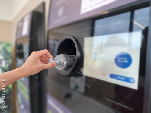 Bringing used water bottles to recycle at vending machines reduces waste and pollution problems and protects the environment. Blurred background.