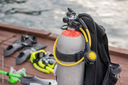 Full set of Scuba Diving equipment with selective focus on wooden pier.