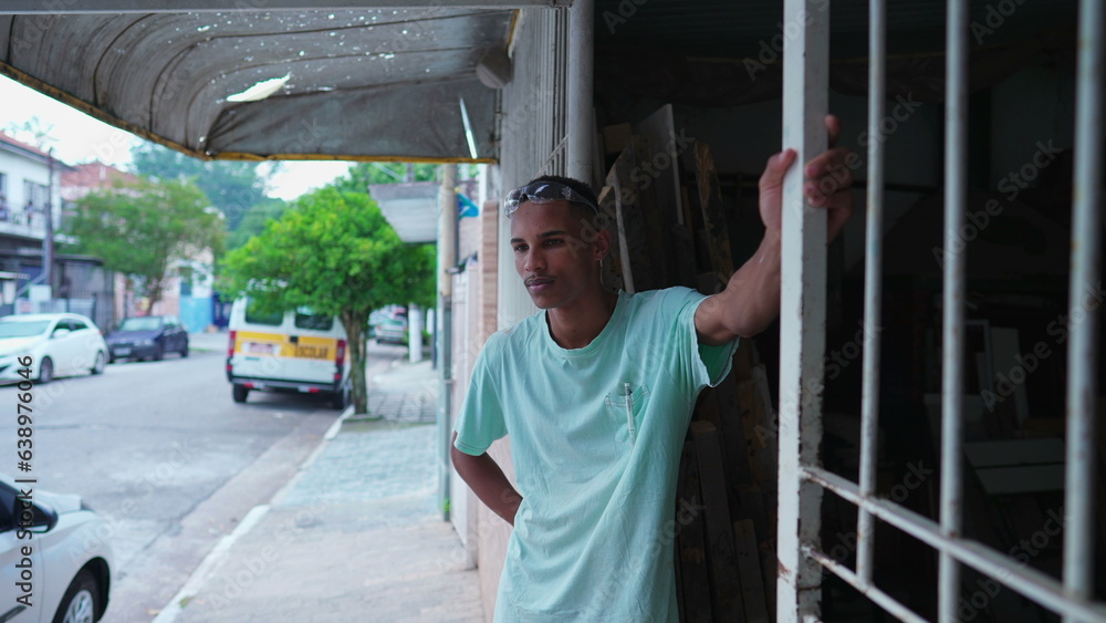 Thoughtful Brazilian Carpenter Taking a Pause from Work, Standing Outside Local Shop