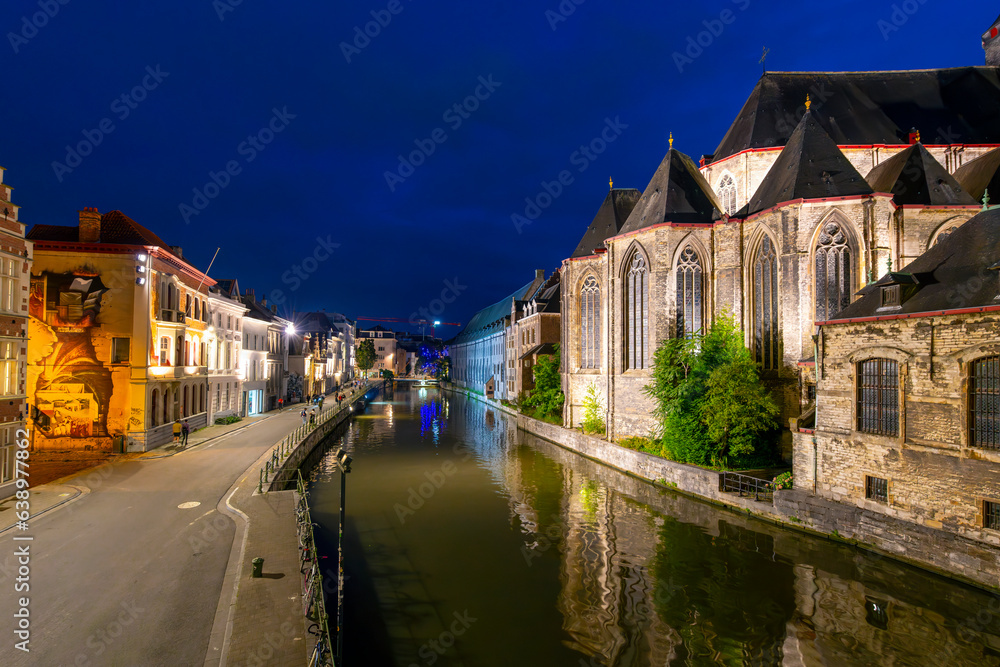 Evening view of the Leie River as it runs past St. Michael's Church in the Korenlei district of the medieval center of Ghent, Belgium.