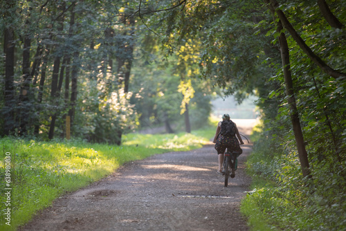 A woman rides a bicycle on a warm summer evening. Ecology and transport. © Show_low