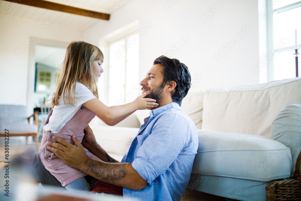 Young caucasian father and daughter hugging and playing together in the living room at home Young caucasian father and daughter hugging and playing together in the living room at home