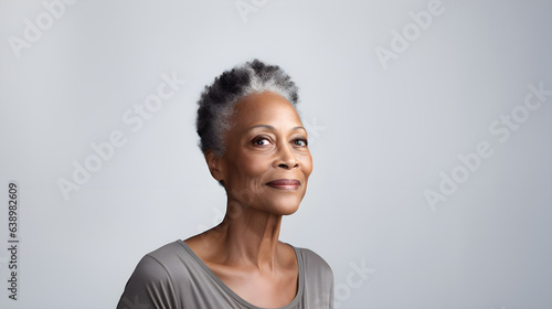 Close up portrait of a beautiful smiling black African-American woman of her 50s mid age on neutral background. Healthy face skin care beauty, skincare cosmetics, dental