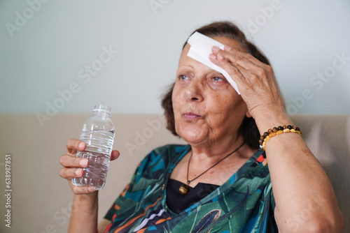 senior woman sweating suffering heat stroke at home