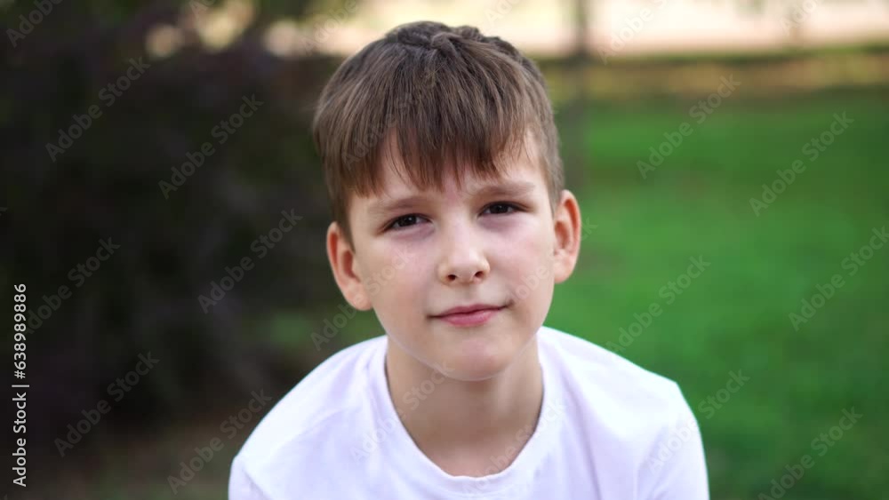 A nine-year-old boy sits quietly on the street. close-up portrait. A nine-year-old boy sits quietly on the street. close-up portrait.