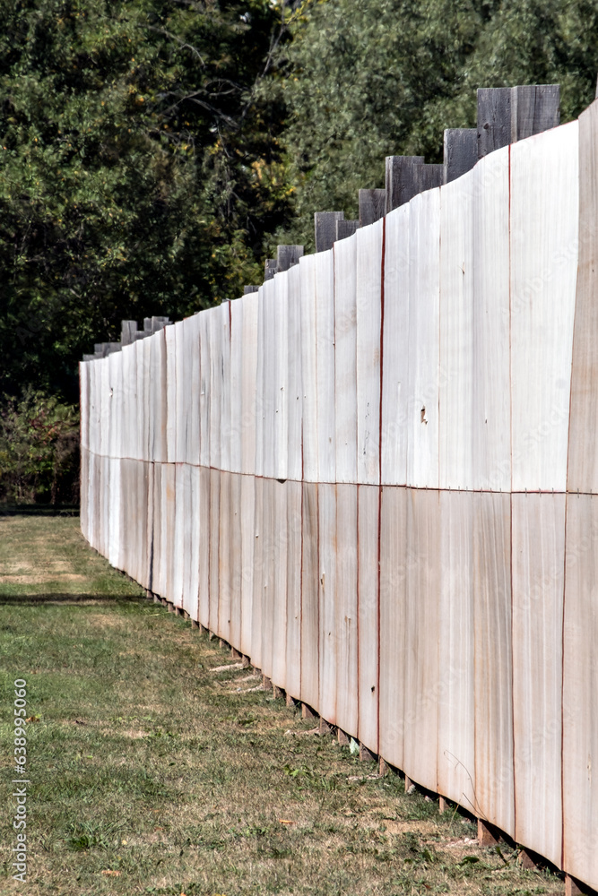 Wooden fence in a park with trees in the background in autumn Wooden fence in a park with trees in the background in autumn