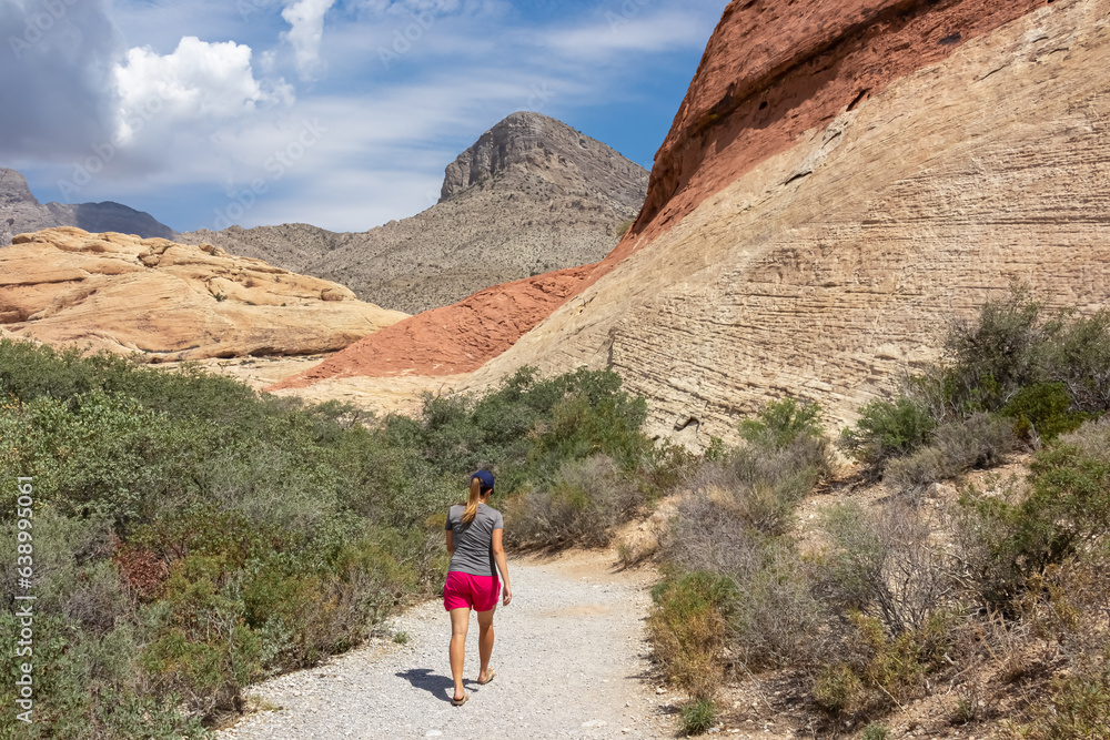 Woman on Sandstone Quarry Overlook path with scenic view of summit Turtlehead Peak of La Madre mountains, Red Rock Canyon National Conservation Area in Mojave Deser, Las Vegas, Nevada, United States
