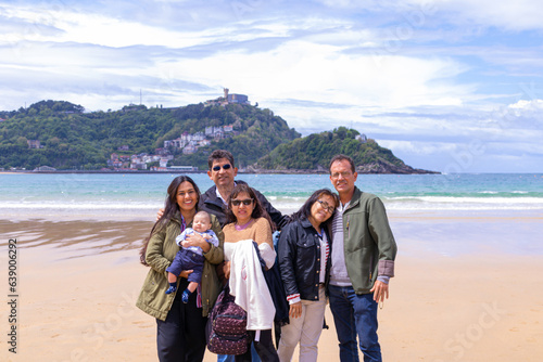 Family of five adults and a baby at the beach and in springtime