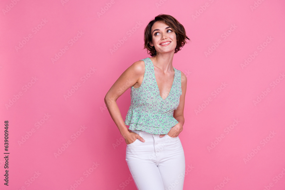 Photo of gorgeous positive girl put arms pockets beaming smile look interested empty space isolated on pink color background Photo of gorgeous positive girl put arms pockets beaming smile look interested empty space isolated on pink color background