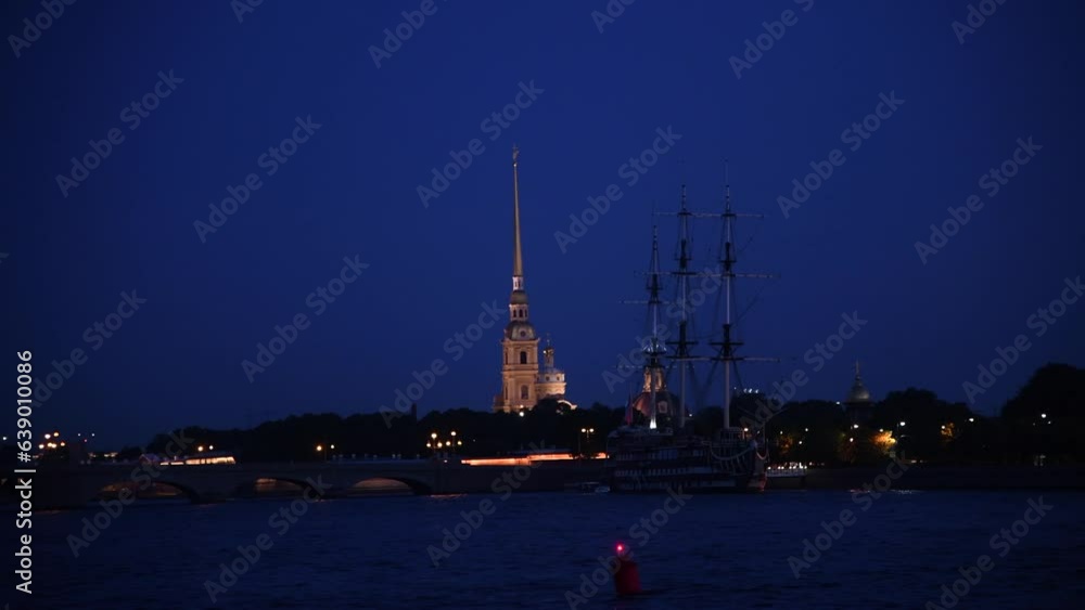 Side view from tour boat of illuminated Russian Orthodox Saints Peter and Paul Cathedral above Trinity bridge at night in Saint Petersburg city, Russia. Real time handheld video. Water travel theme. Side view from tour boat of illuminated Russian Orthodox Saints Peter and Paul Cathedral above Trinity bridge at night in Saint Petersburg city, Russia. Real time handheld video. Water travel theme.