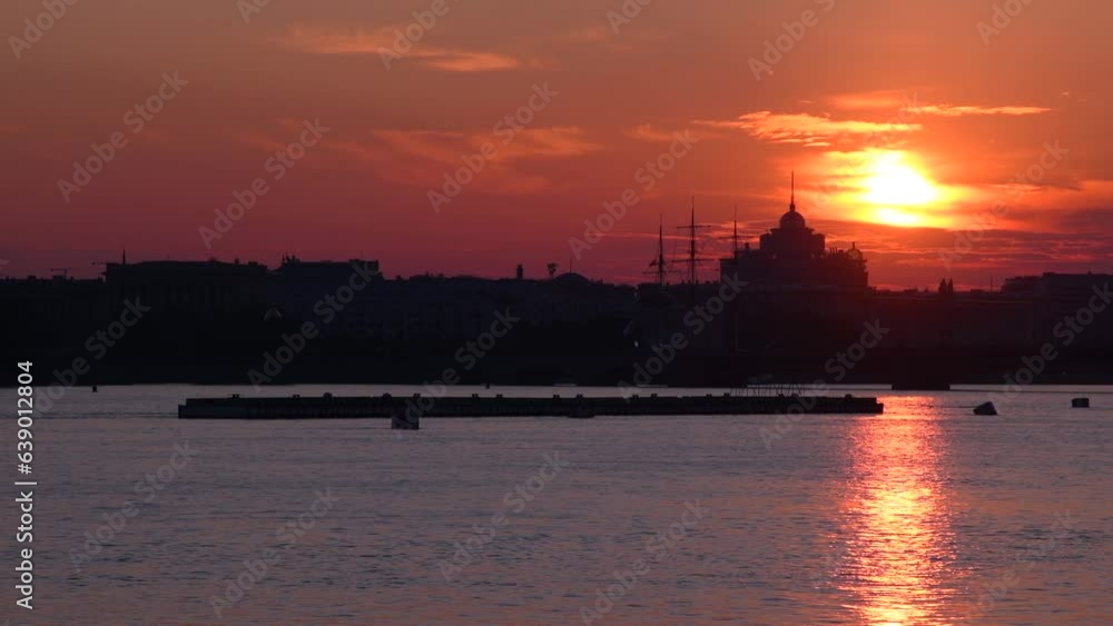 Saint Petersburg cityscape at sunrise. Black embankment building silhouettes above neva river with sunlight trail. Red morning sky and orange sun. Copy space. Real time video. Abstract city background Saint Petersburg cityscape at sunrise. Black embankment building silhouettes above neva river with sunlight trail. Red morning sky and orange sun. Copy space. Real time video. Abstract city background