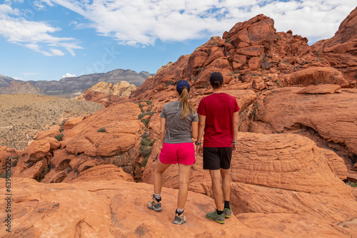 Canvas Print Couple standing on rocks with scenic view of Aztec sandstone slickrock outcrop o