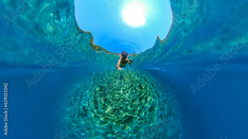 Man snorkeling with 360 degree underwater camera in the beautiful, crystal clear sea at Zuljana beach, Croatia photo