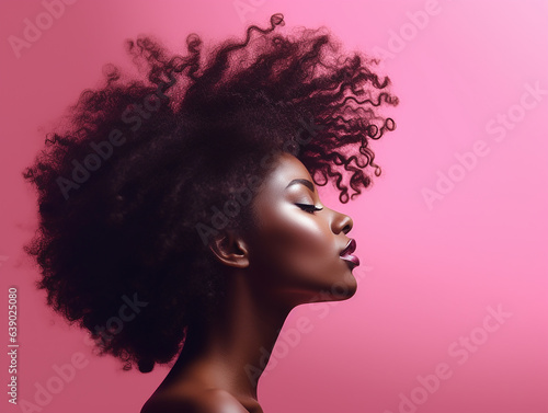 beautiful woman portrait with afro hair in profile smiling on pink background photo