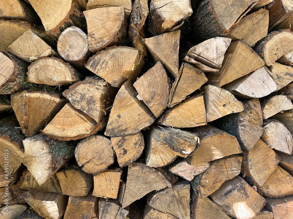 Firewood in a heap,prepared for the winter. Stacked firewood background. Dry textured firewood. Chopped wooden logs. Rustic background. Selective focus. Firewood in a heap,prepared for the winter. Stacked firewood background. Dry textured firewood. Chopped wooden logs. Rustic background. Selective focus.