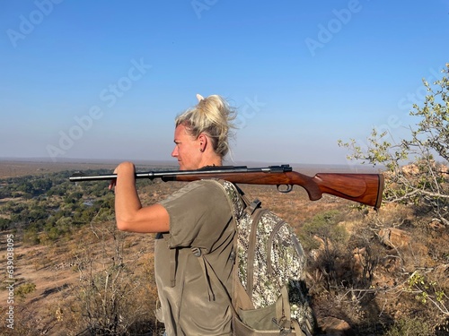 Woman Holding Gun with Backpack Overlooking Mountain with Binoculars in South Africa