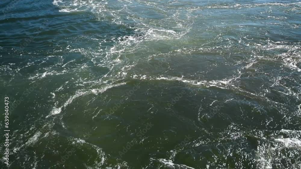 Water ripples behind the ferry boat as it starts up. Water ripples behind the ferry boat as it starts up.