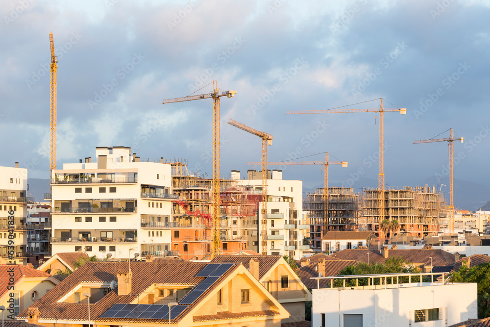 view of various cranes in a city, rooftops and buildings under construction. Speculation, industry. view of various cranes in a city, rooftops and buildings under construction. Speculation, industry.