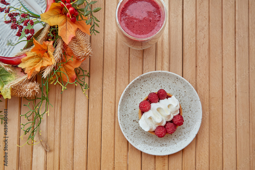 French aesthetic food - raspberry tart, healthy pink smoothie and autumn decorations on the wooden table