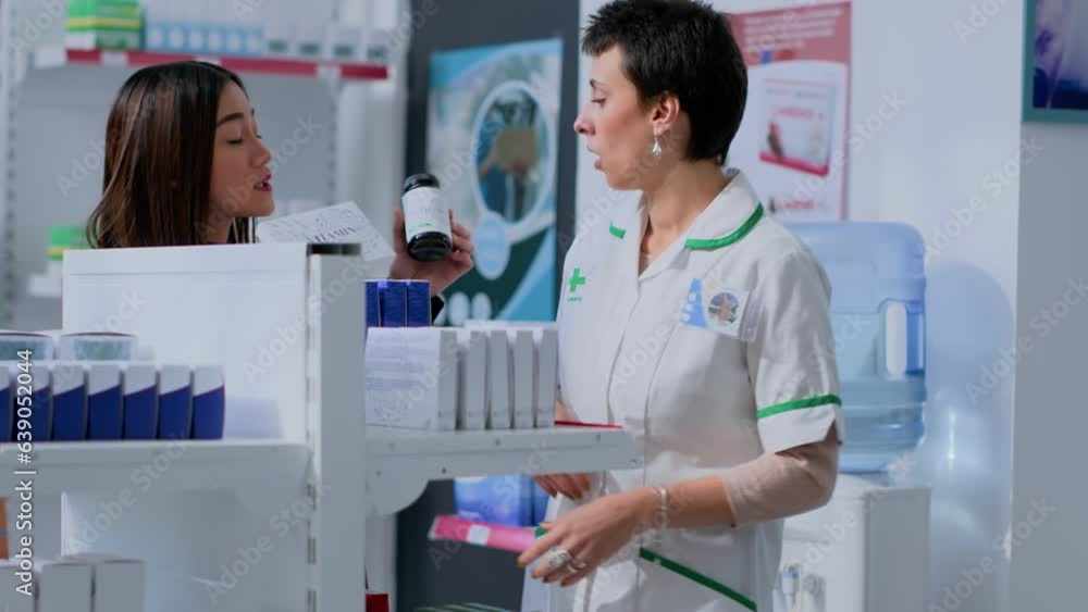 Healthcare expert taking break from arranging merchandise on shelves to help customer with medical suggestions. Shopper wishing to purchase pharmacological product, asking pharmacist for advice Healthcare expert taking break from arranging merchandise on shelves to help customer with medical suggestions. Shopper wishing to purchase pharmacological product, asking pharmacist for advice