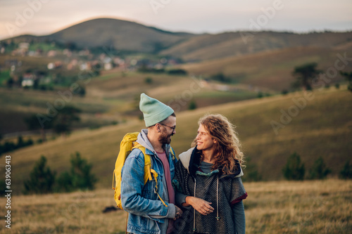Couple of hikers walking along mountain grassy trail during a vacation