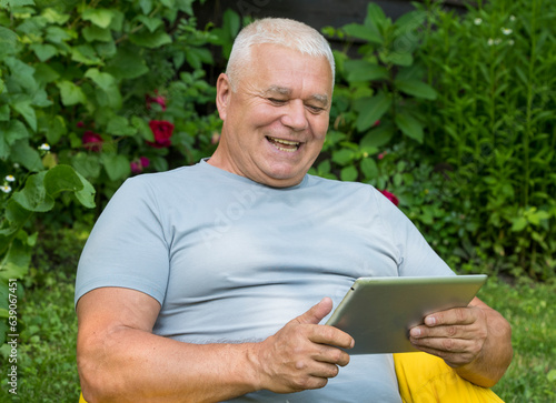 elderly man in the garden with laptop tablet