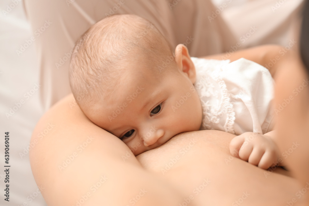 Young woman breastfeeding her baby in bedroom, closeup Young woman breastfeeding her baby in bedroom, closeup