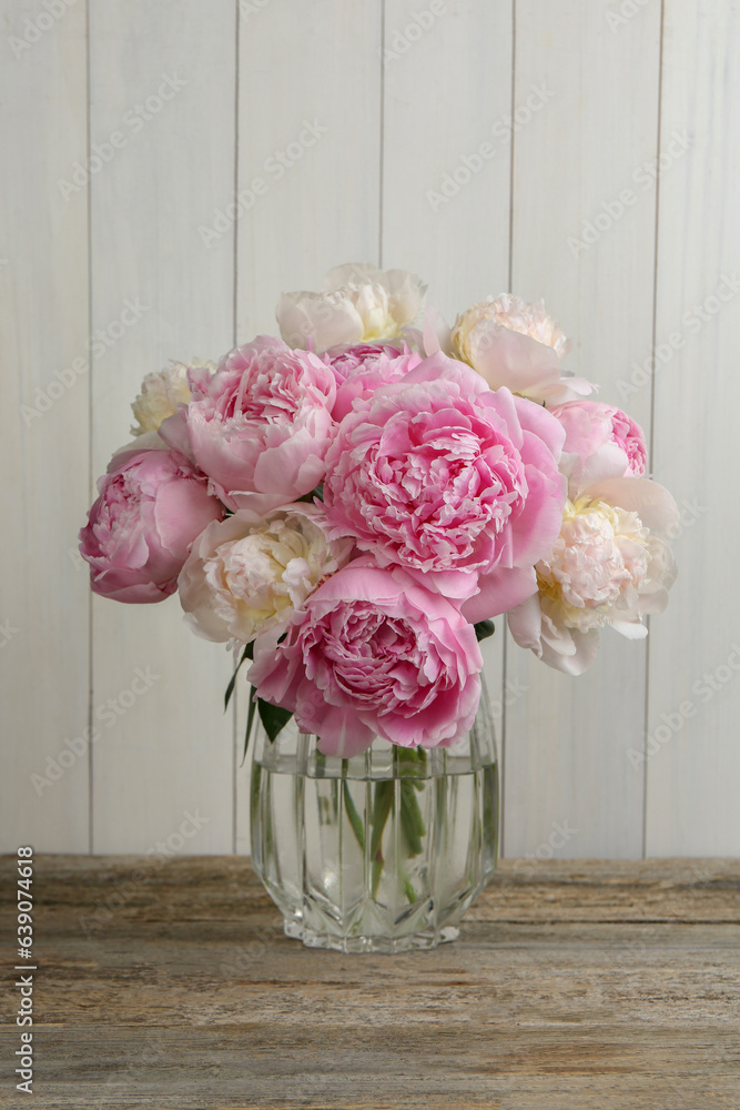 Beautiful peonies in vase on wooden table Beautiful peonies in vase on wooden table