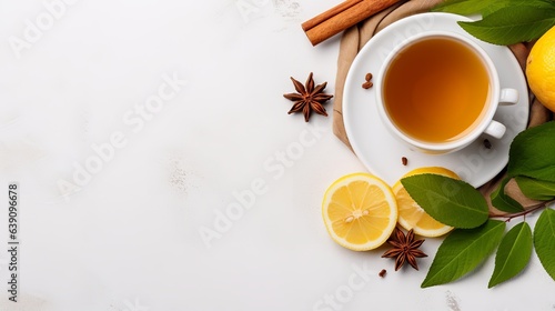 Top view tea and cinnamon a cup of herbal tea cinnamon sticks on the saucer lemon teapot and leaves on the white table