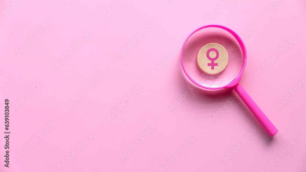 Questions and answers about women concept. Women symbol over a magnifying glass on pink background with copy space. Questions and answers about women concept. Women symbol over a magnifying glass on pink background with copy space.