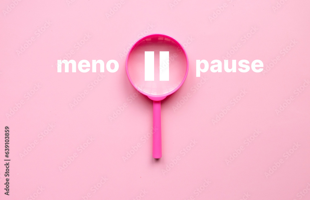 Menopause concept. Pink magnifying glass with pause symbol with a text on pink background. Menopause concept. Pink magnifying glass with pause symbol with a text on pink background.