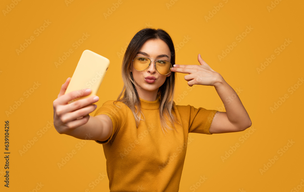 Trendy young female taking selfie Trendy young female taking selfie